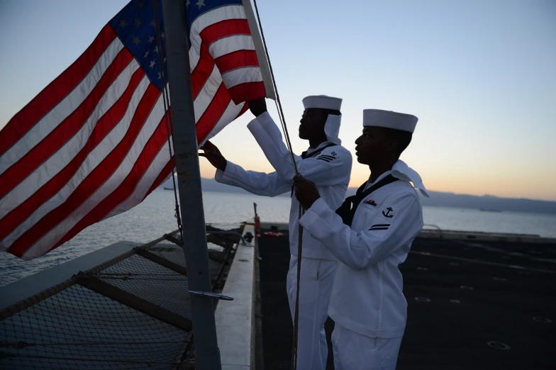 two men in sailor uniforms and one has an american flag