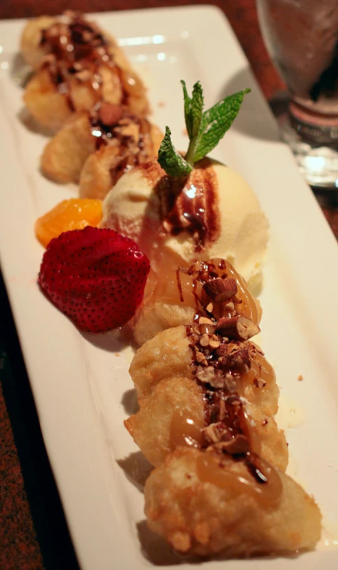 two dessert plates with banana, fruit and ice cream