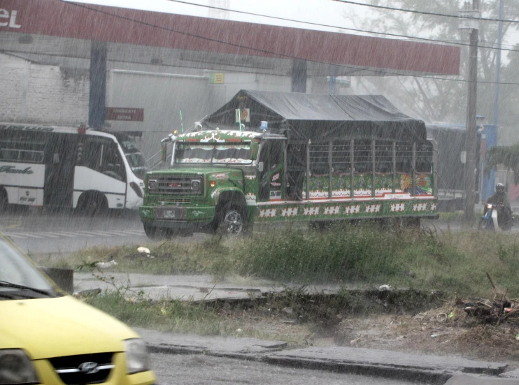 the truck is hauling produce on the rainy street