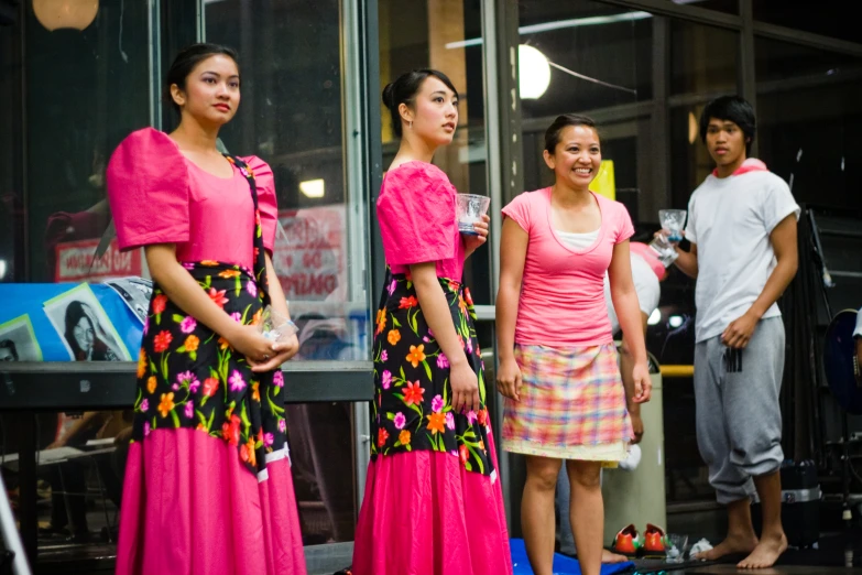 a group of young women wearing dresses standing next to each other