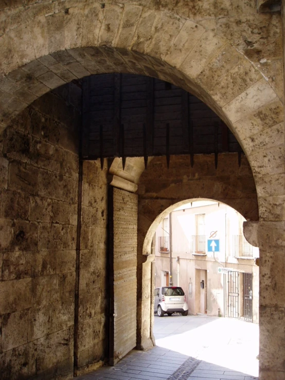 a cobble stone archway with an open doorway on the side