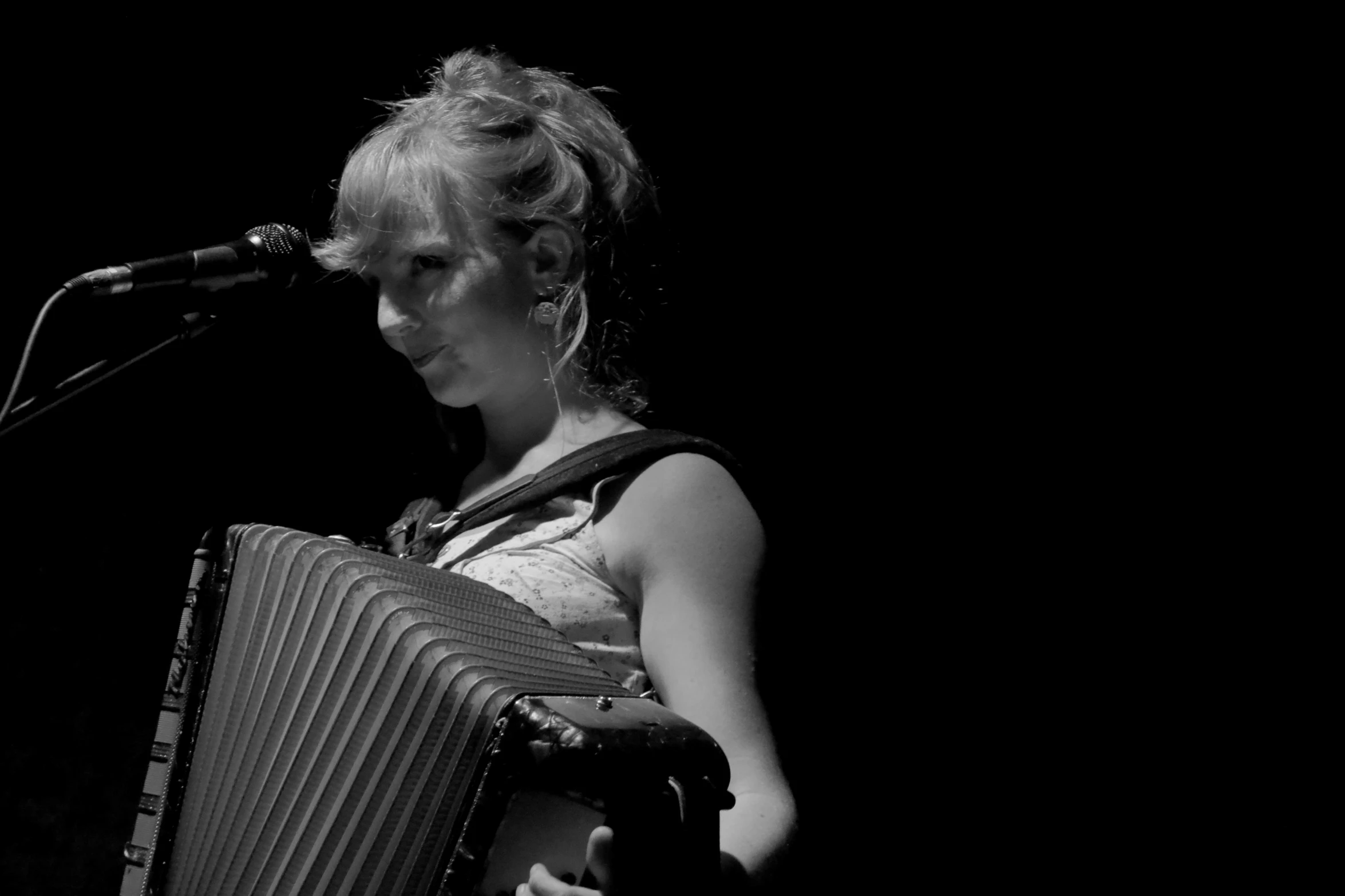 black and white pograph of a woman playing an accordion
