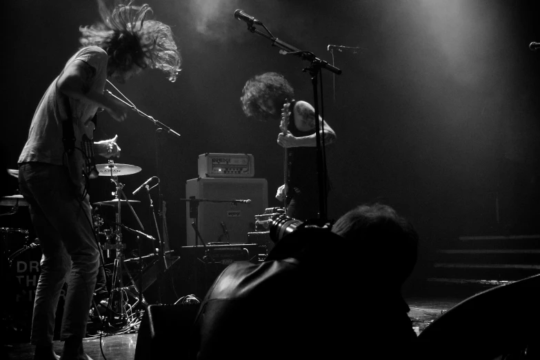 a band playing on stage with their heads in the air