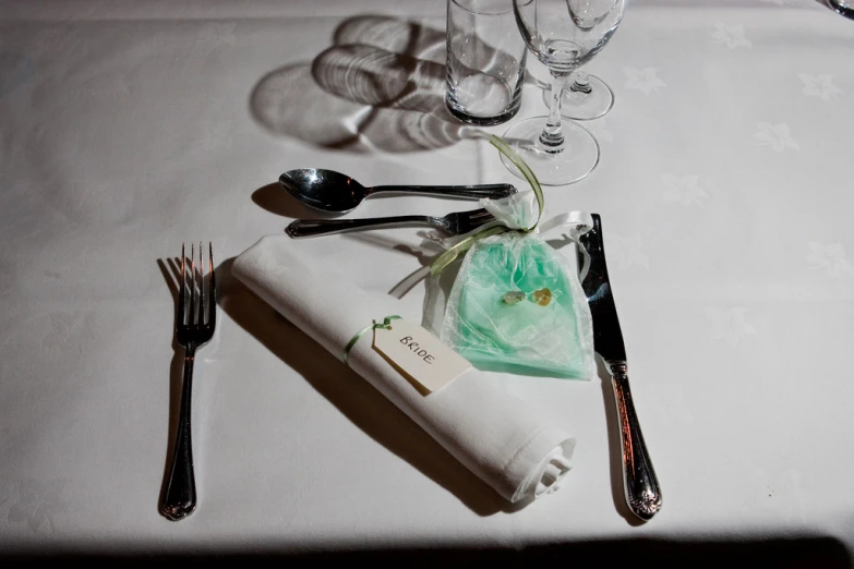 the napkin is next to the wine glasses and a silverware