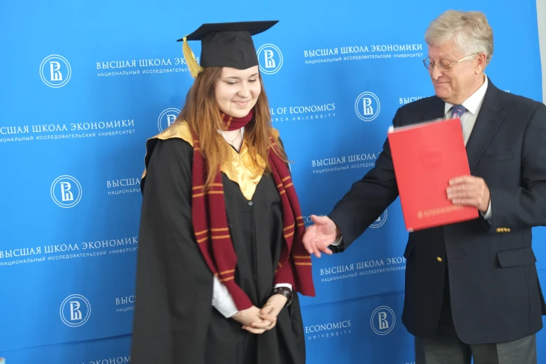 the woman is holding a diploma certificate for her graduates