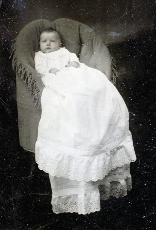 black and white pograph of small child wrapped in blankets