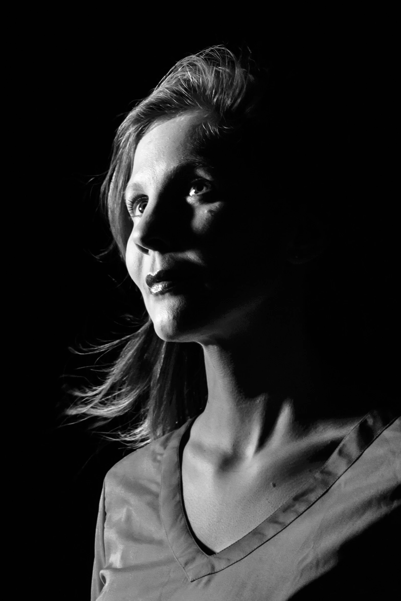 a black and white pograph of a woman looking off to the side