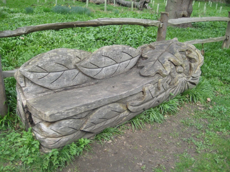 a bench made out of wood and carved with leaves