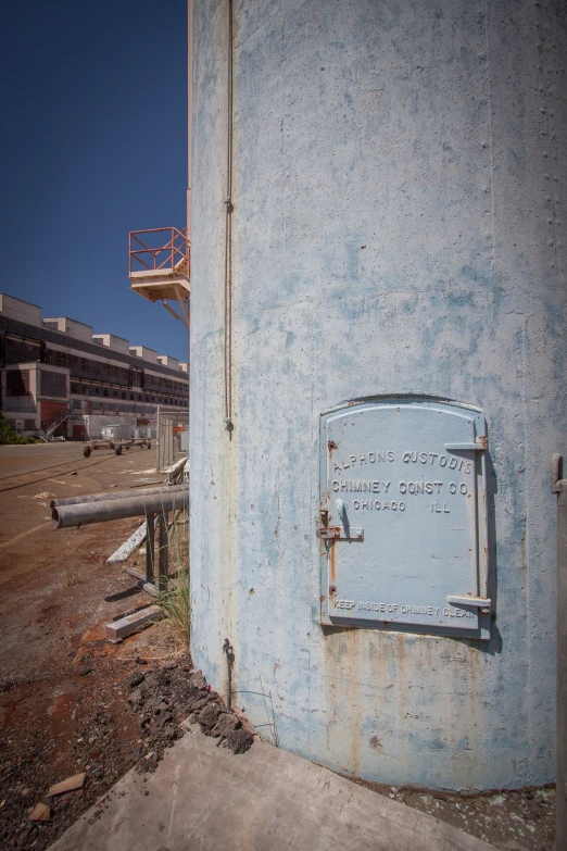 an old water fountain sits next to an abandoned building