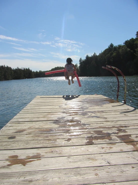 a person on a pier is jumping with a kite