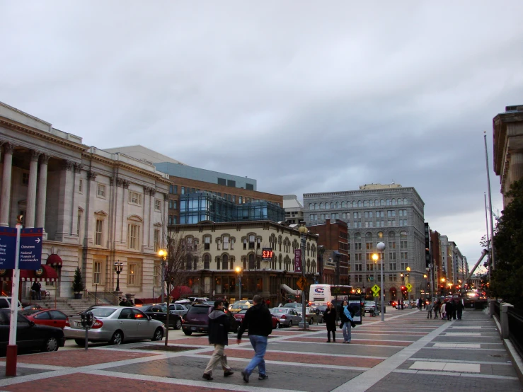 people walking across the street in a city