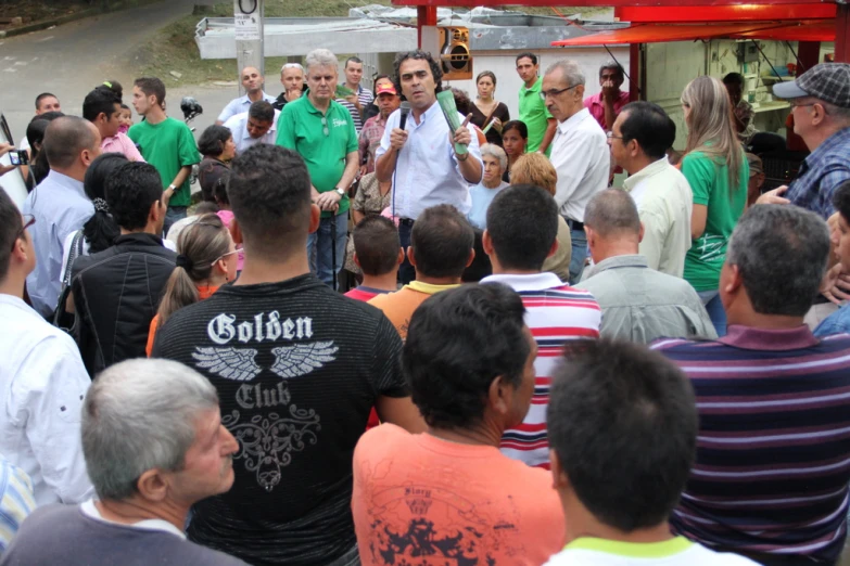 a crowd of people stand together outside talking