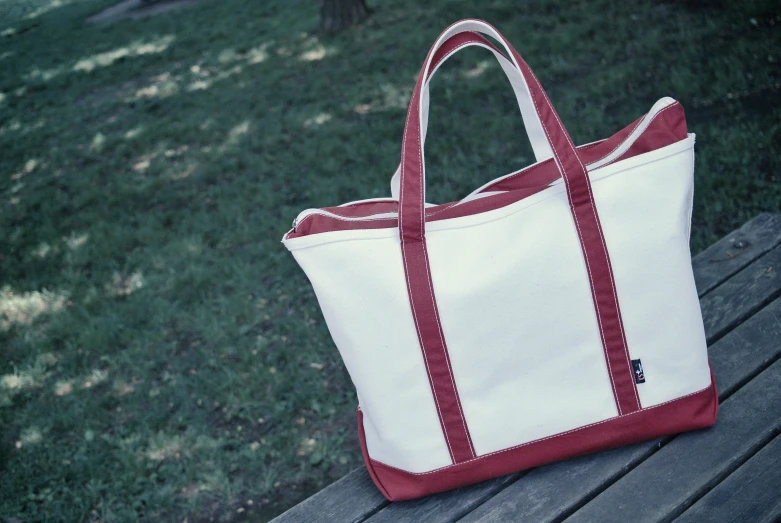 white and red bag sitting on the park bench