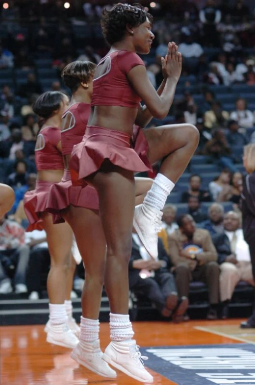 two basketball players wearing red cheerleader outfits on the court