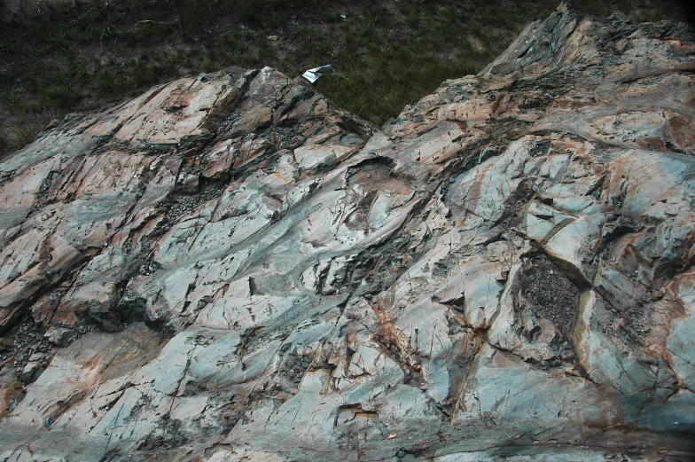 a very tall rocky hill with lots of rock and moss on it