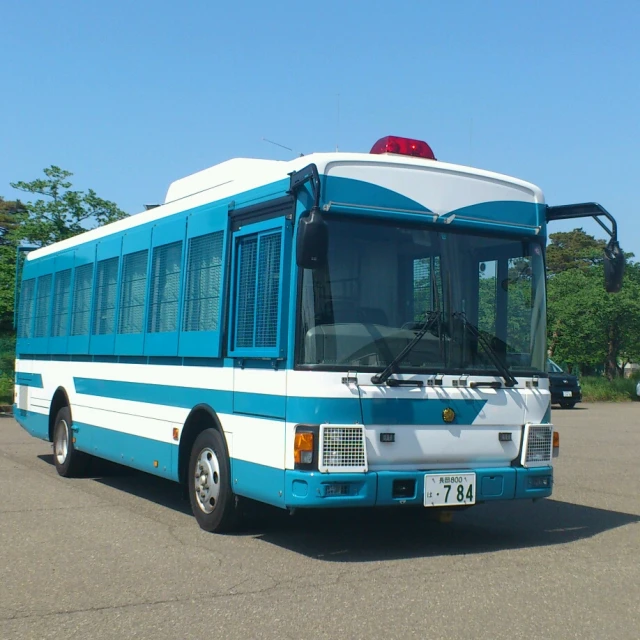a blue and white bus parked in a parking lot
