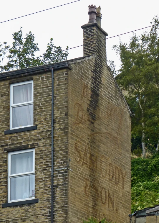 a very old brick building with graffiti writing