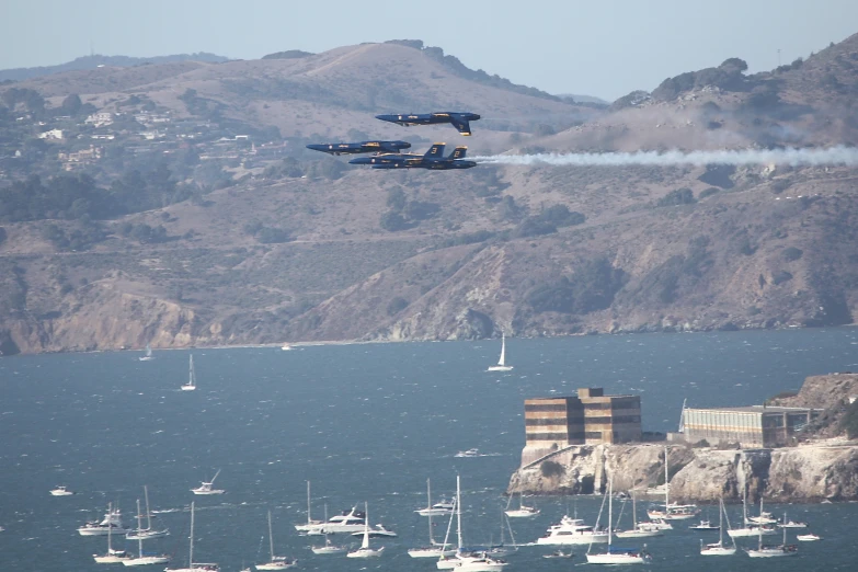 there are two fighter jets flying in the sky above the water