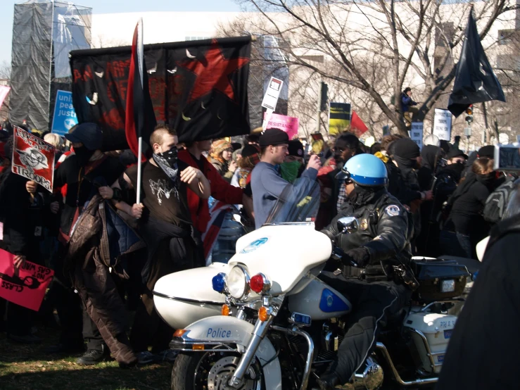 several protestors and protesters gather with flags, helmets, bikes, and signs