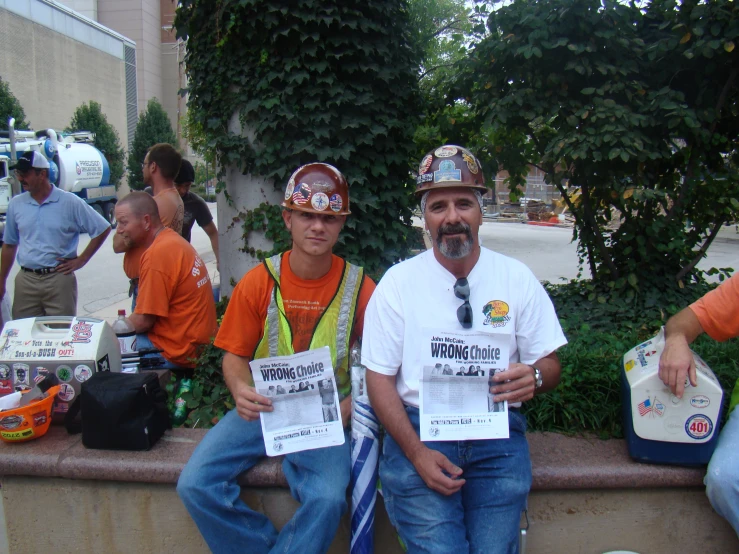 three people wearing helmets at a fair hold signs