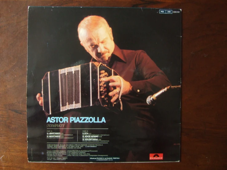 a poster on top of a wooden table displaying an older man playing the accordion