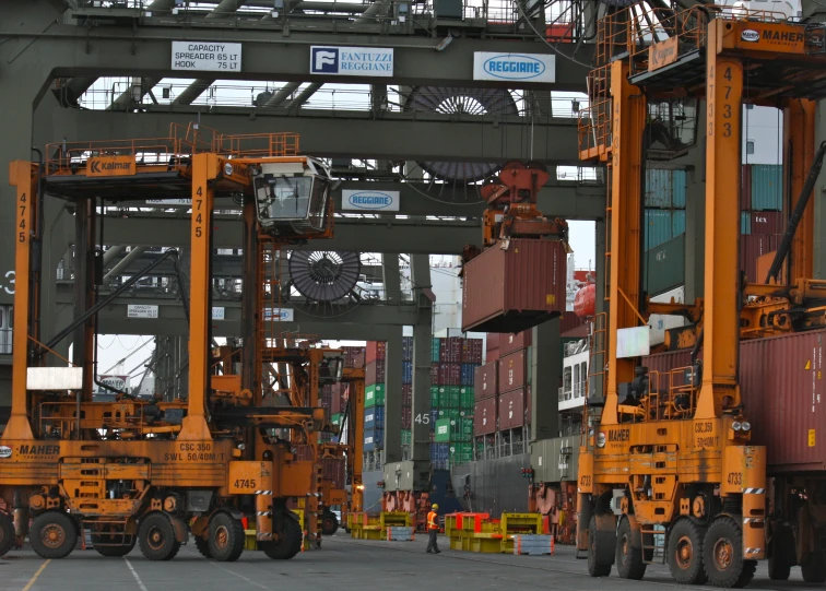 yellow truck cranes at dock under steel structure