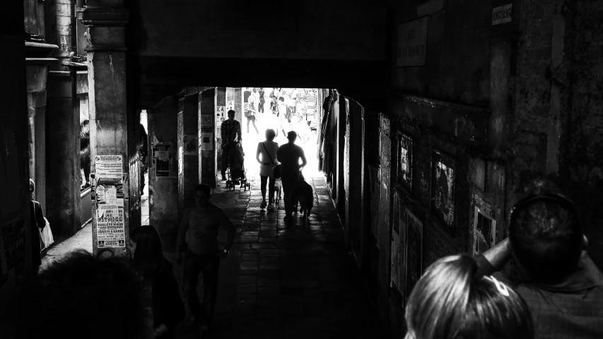 people standing in an alley as one man walks past them