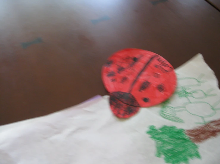 a lady bug pin sits on top of a napkin