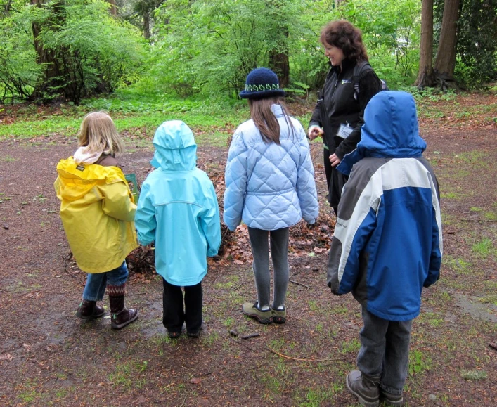 a group of children standing next to each other near trees