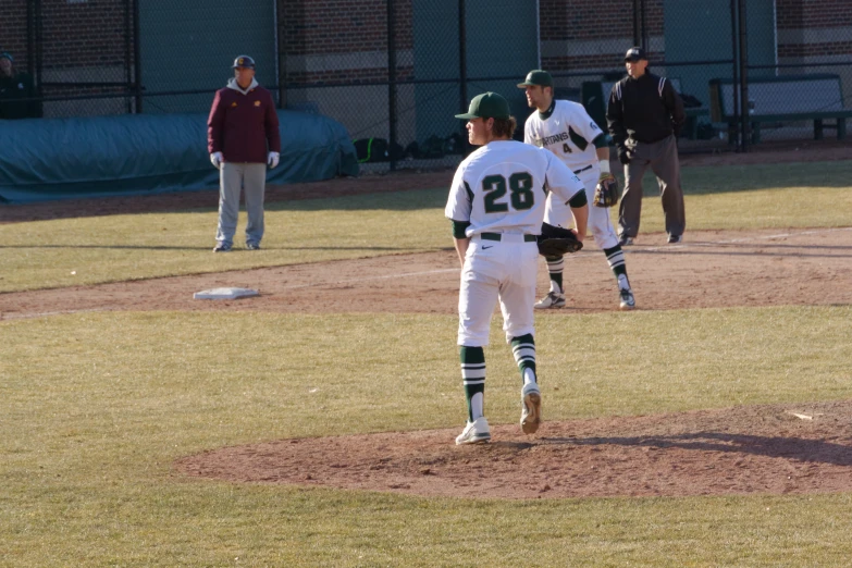 two baseball players stand on a dirt mound