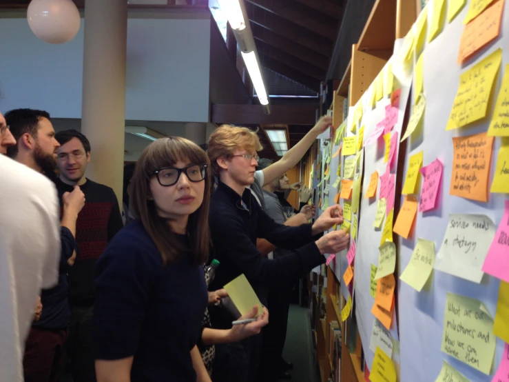 people looking at sticky notes in a group