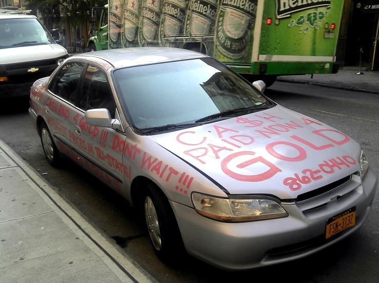 a silver car with a red sign painted on the side