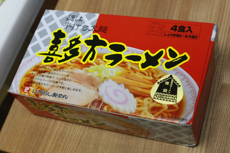 a bowl of noodles with asian writing on the box