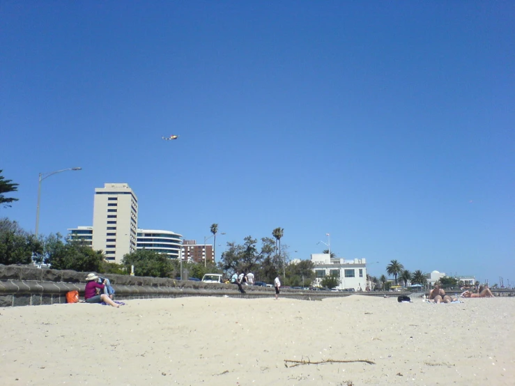 people are at the beach flying kites