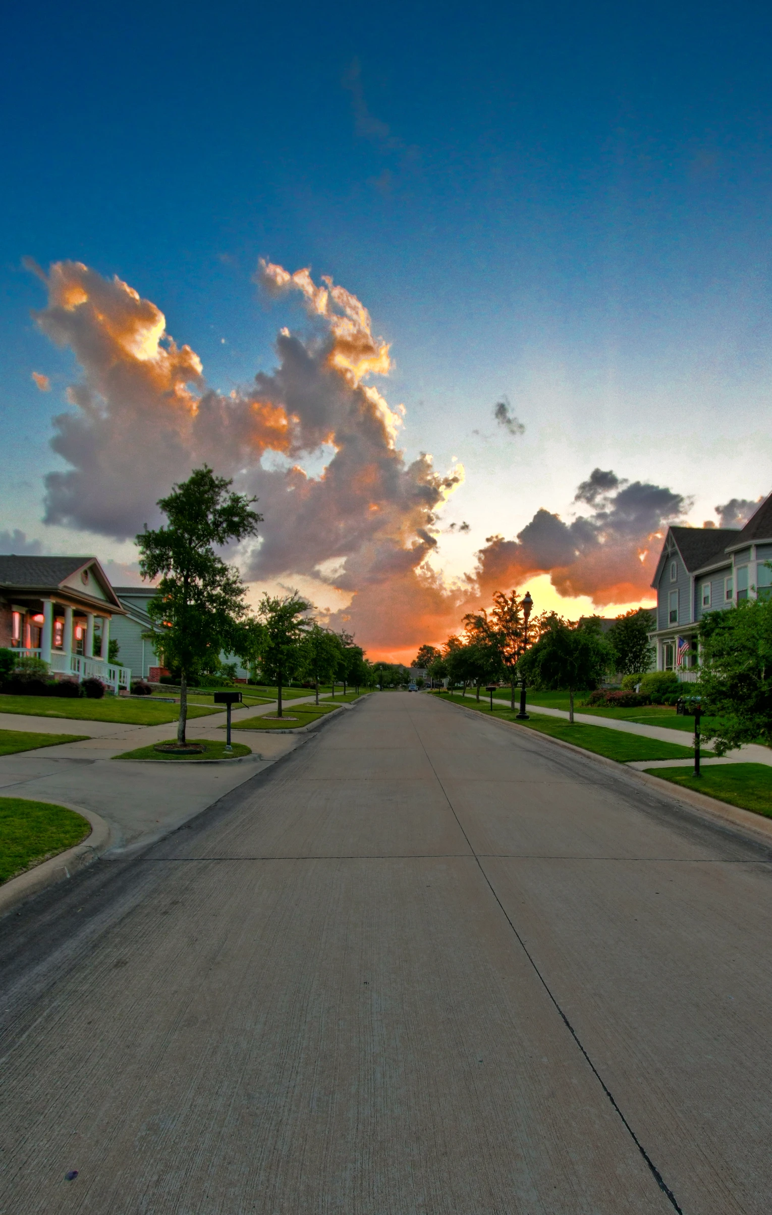 a city street at sunset with a light pole above