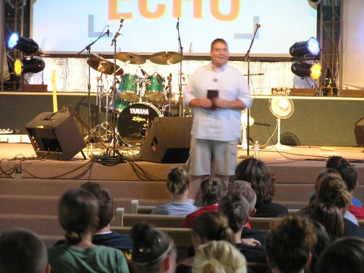 a man standing on stage addressing an audience