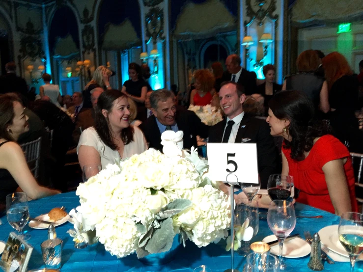 people sitting around a blue table at a formal function