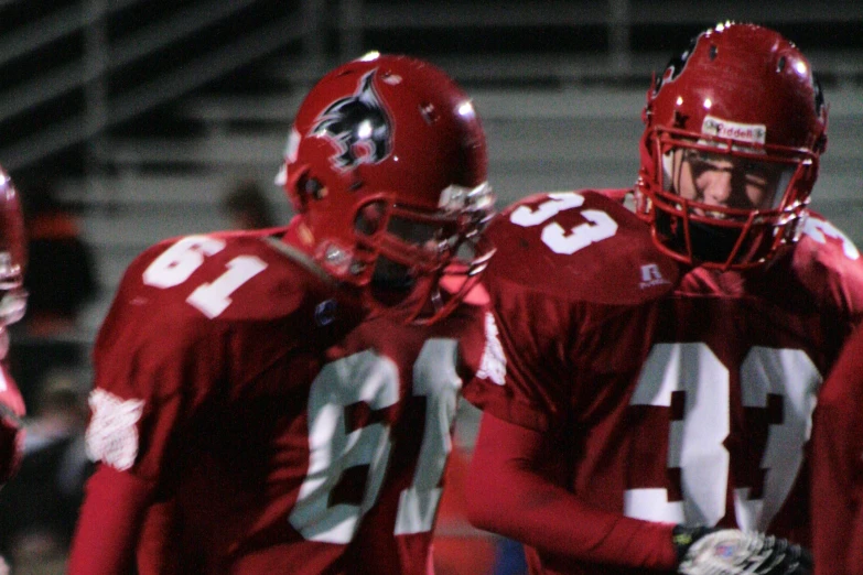 two football players standing on the sidelines with each other