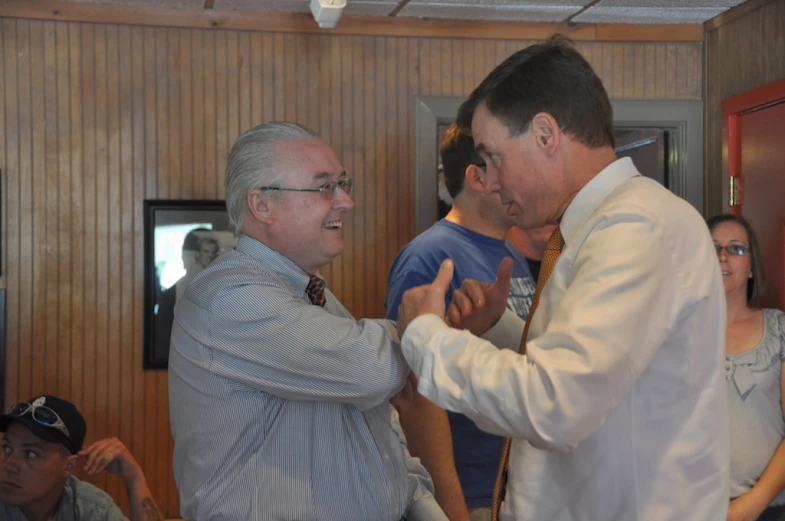 a group of men with white shirts and tie talking