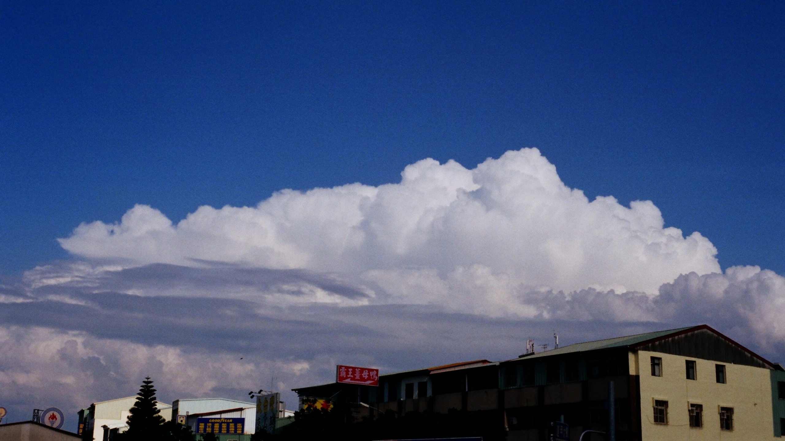a large cloud formation over a city on a sunny day