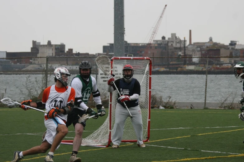 two young men are playing lacrosse on a field