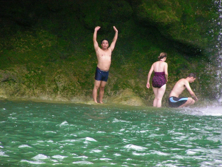 the two men are playing with water from a waterfall