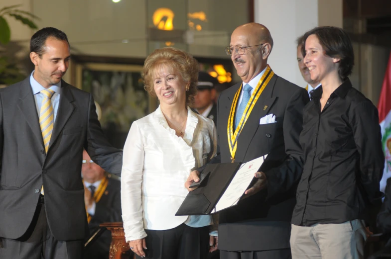 three people standing next to each other holding papers