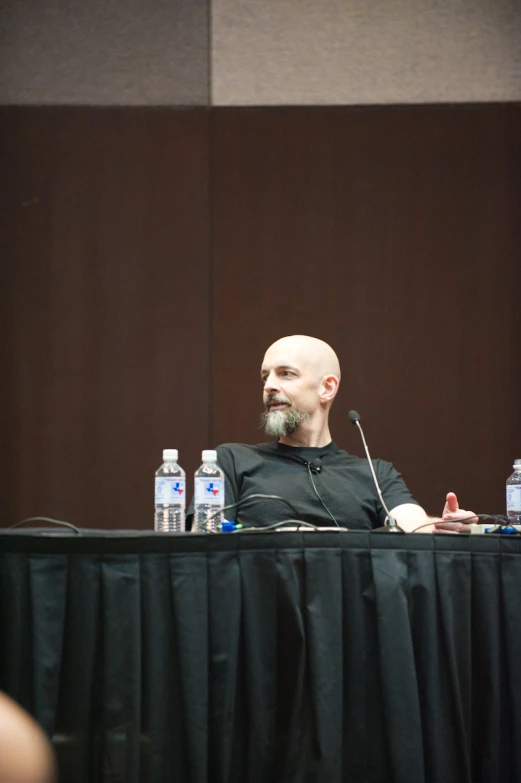 man with bald head and glasses sitting at a table