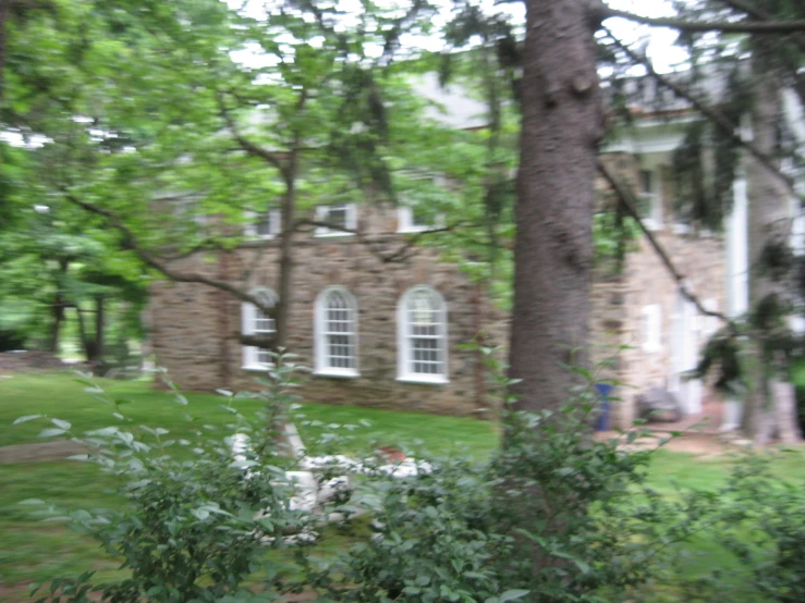 an old brick house surrounded by trees and grass