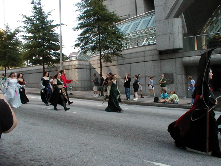 some people are dressed up in costumes walking in the street