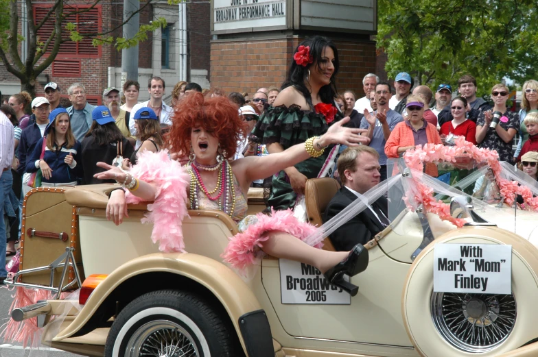 a woman driving in the back of a convertible