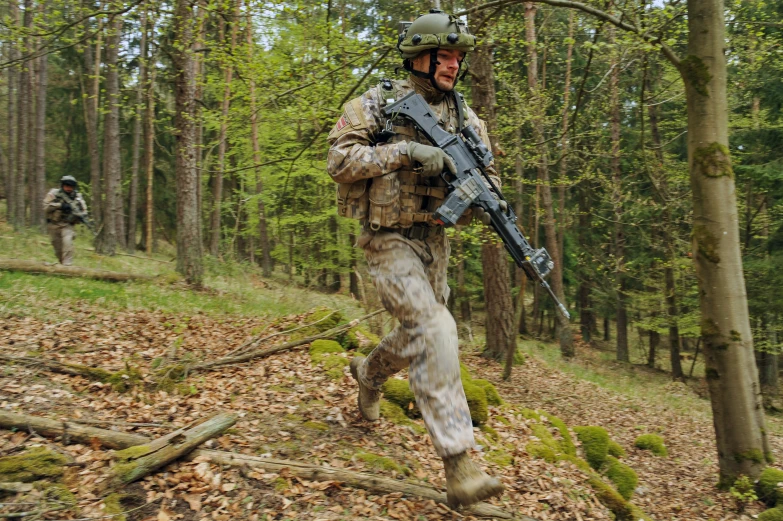 a soldier running in a wooded area while carrying a machine gun