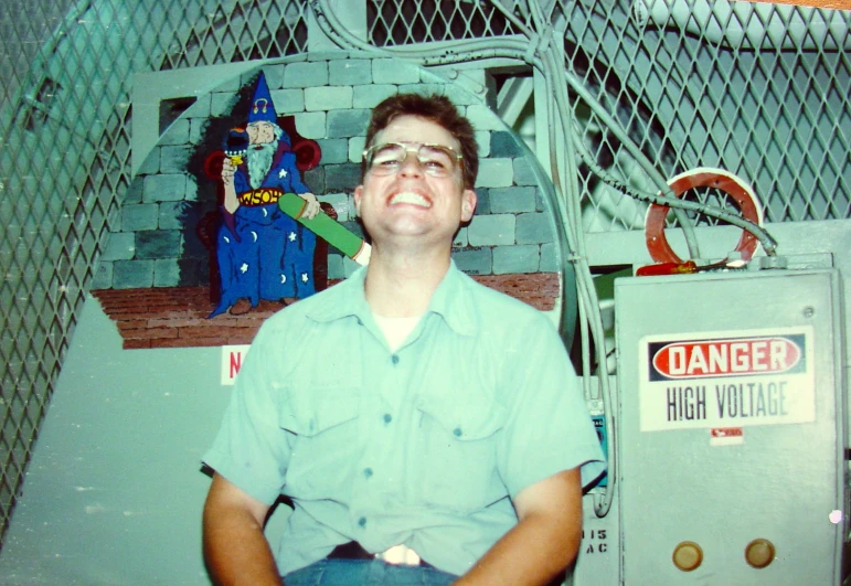 a man sits in front of a cartoon wall