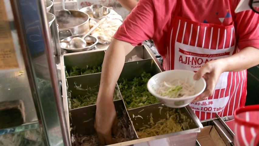 man in red shirt and apron putting food into dishes